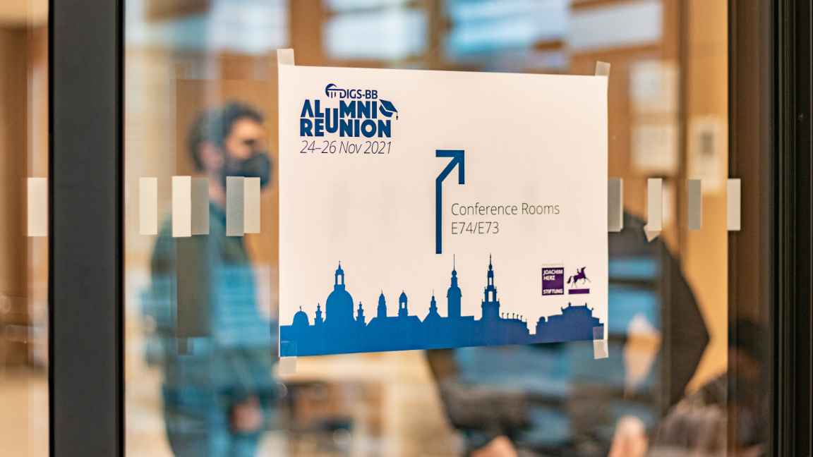 A door sign leading to the conference room, people blurry in the background